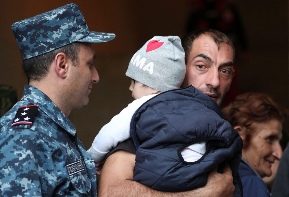 Un hombre llega a Goris con su bebé en brazos (REUTERS/Irakli Gedenidze)