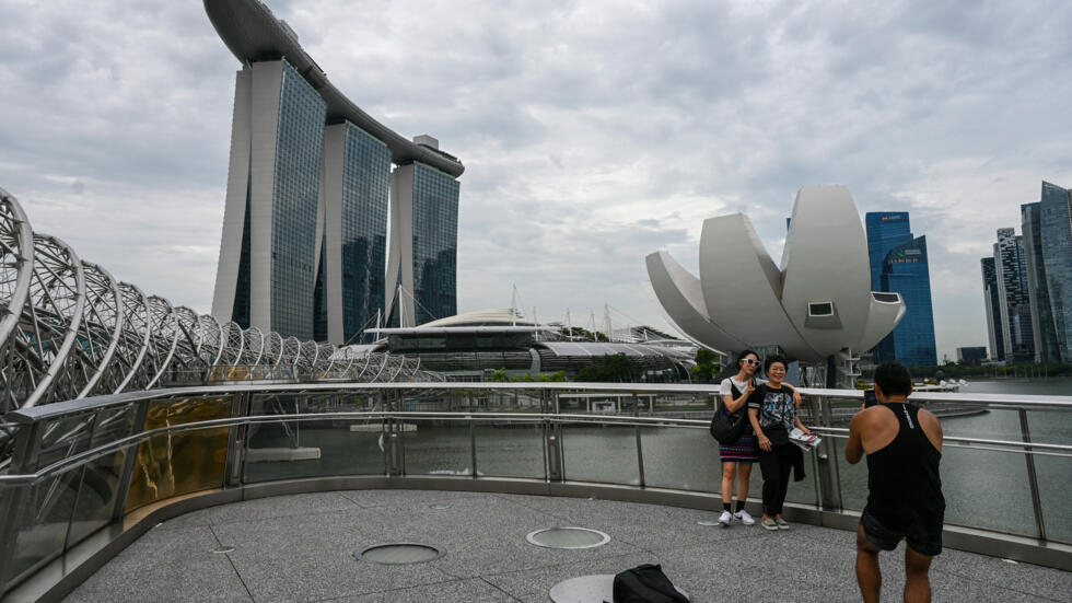 Unas personas se hacen fotos en el puente de Helix con los rascacielos de Singapur de fondo, el 22 de noviembre de 2023 en la ciudad asiática