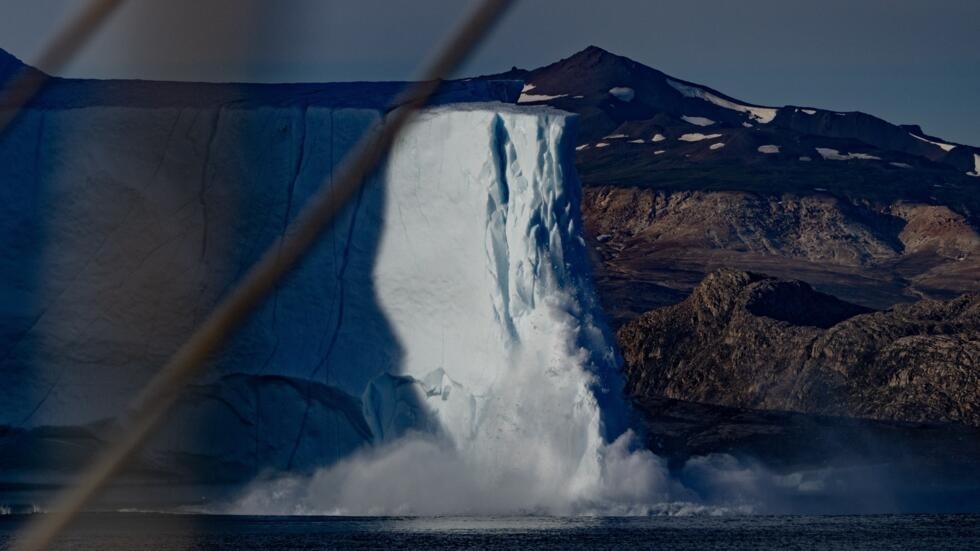 Una pieza de iceberg derretido cae al mar en el fiordo Scoresby, en Groenlandia, el 15 de agosto de 2023