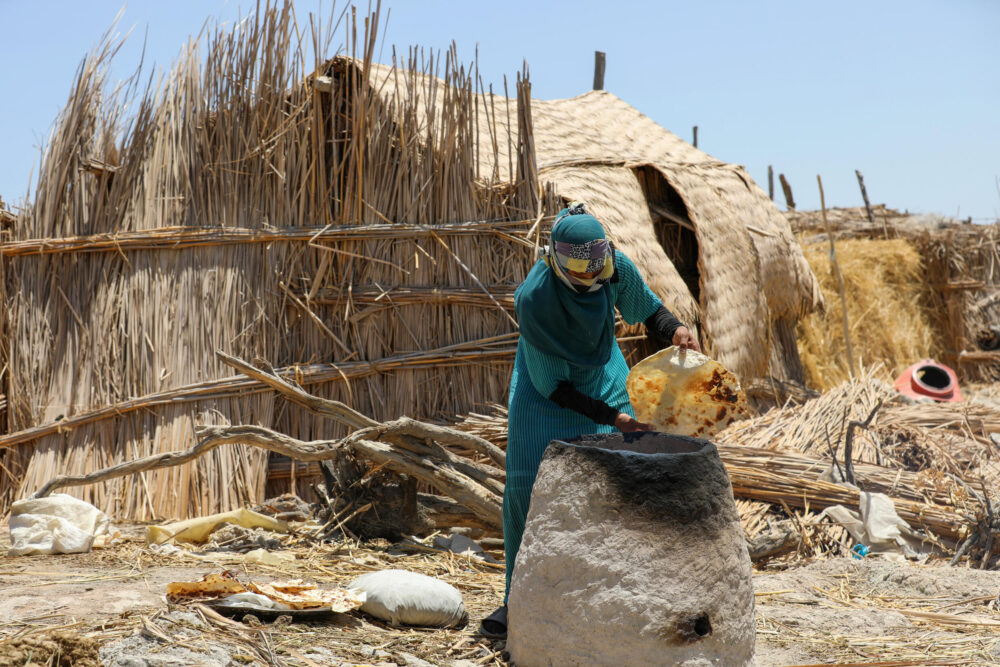 Una mujer hornea pan en las marismas de Chibayish, en la provincia iraquí de Dhi Qar, en una imagen del 22 de junio de 2023
