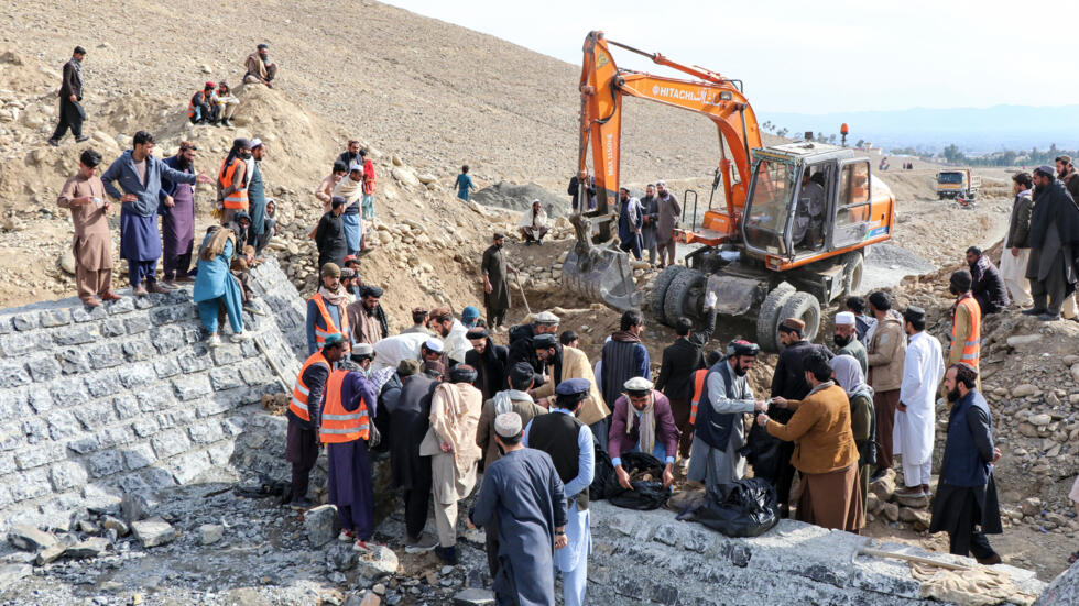 Residentes afganos y empleados municipales en torno a una fosa común descubierta en la provincia de Khost, en el este de Afganistán, el 12 de febrero de 2024