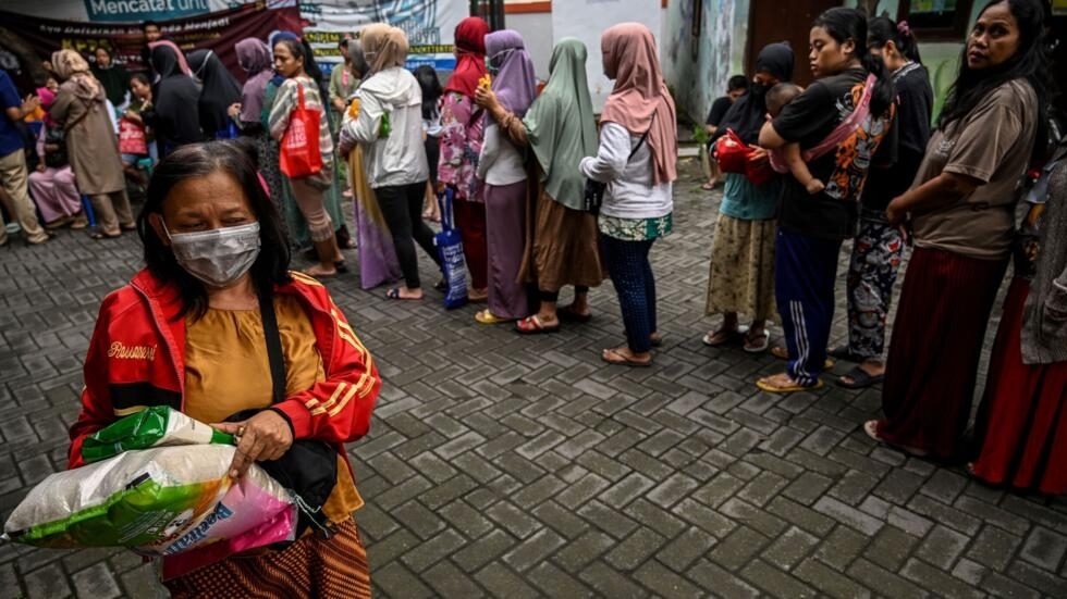 Una cola de personas aguarda a comprar alimentos básicos en un mercado barato auspiciado por el gobierno de Indonesia para mantener estables los precios, el 12 de marzo de 2024 en Surabaya, en la isla de Java