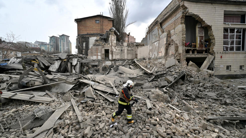 Un rescatista ucraniano trabaja entre los escombros dejados por un ataque con misil en Kiev el 25 de marzo de 2024