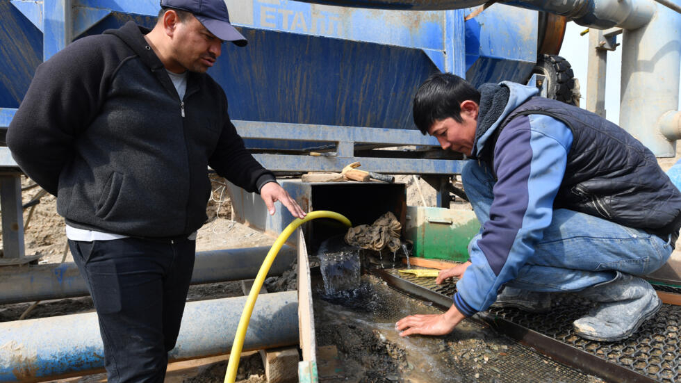 Zahit Khudaberdiev (I), busca oro con un empleado en Soykechar, Uzbekistán, el 6 de marzo de 2024