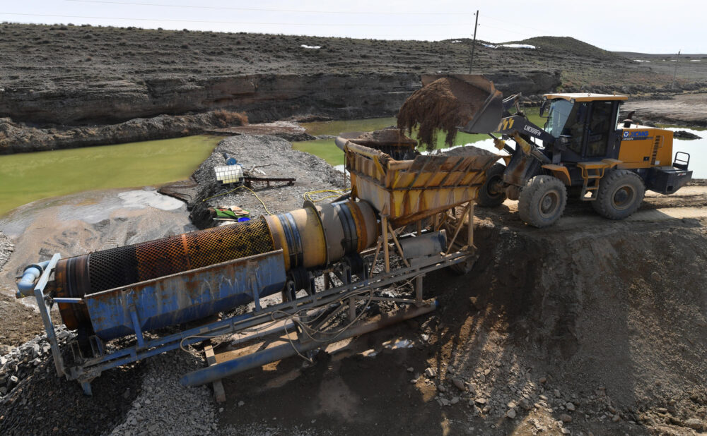 Una excavadora carga a un camión una mezcla de arena y piedras que contiene partículas de oro cerca de Soykechar, Uzbekistán, el 6 de marzo de 2024