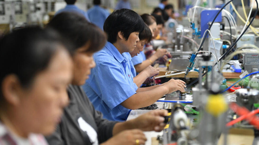 Empleados trabajan en una cadena de montaje produciendo altavoces en una fábrica de la ciudad de Fuyang, en la provincia oriental china de Anhui, el 31 de agosto de 2022.