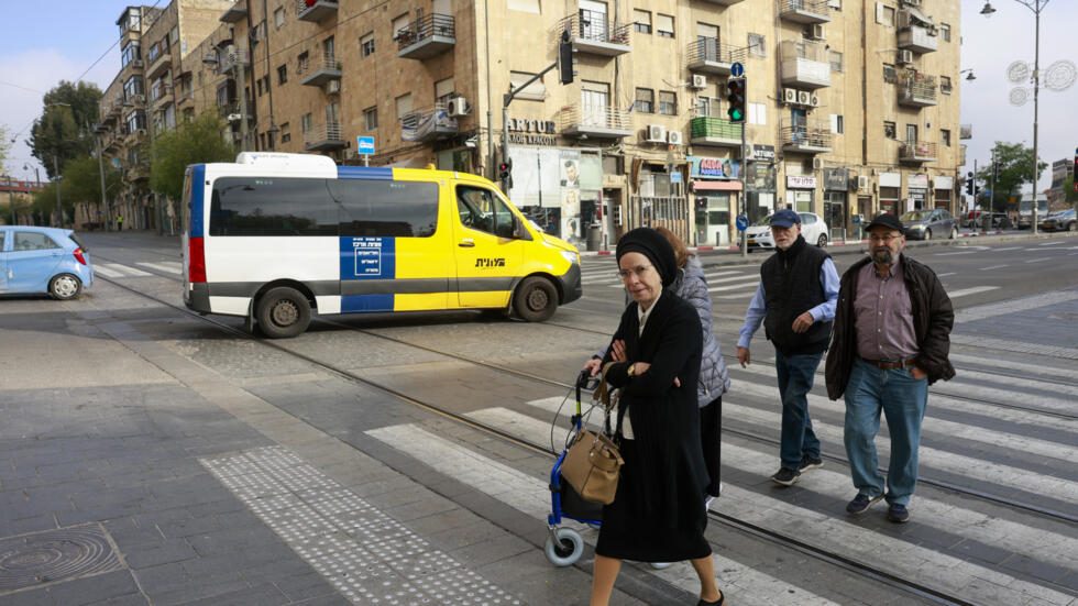 Personas cruzando la calle en Jerusalén el 14 de abril de 2024