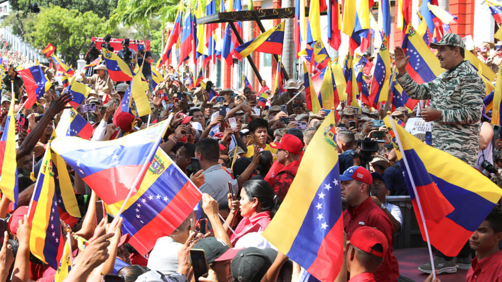 El presidente de Venezuela, Nicolás Maduro (drcha.), saluda durante un acto político en Caracas el 13 de abril de 2024