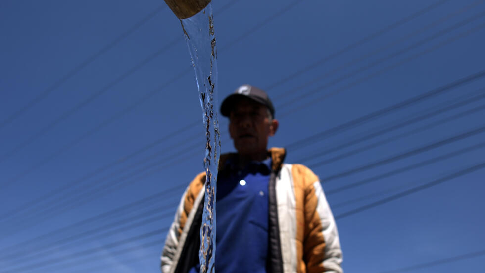 Un hombre recoge agua con cubos ante los cortes del servicio de acueducto en La Calera, un municipio vecino a Bogotá, el 10 de abril de 2024
