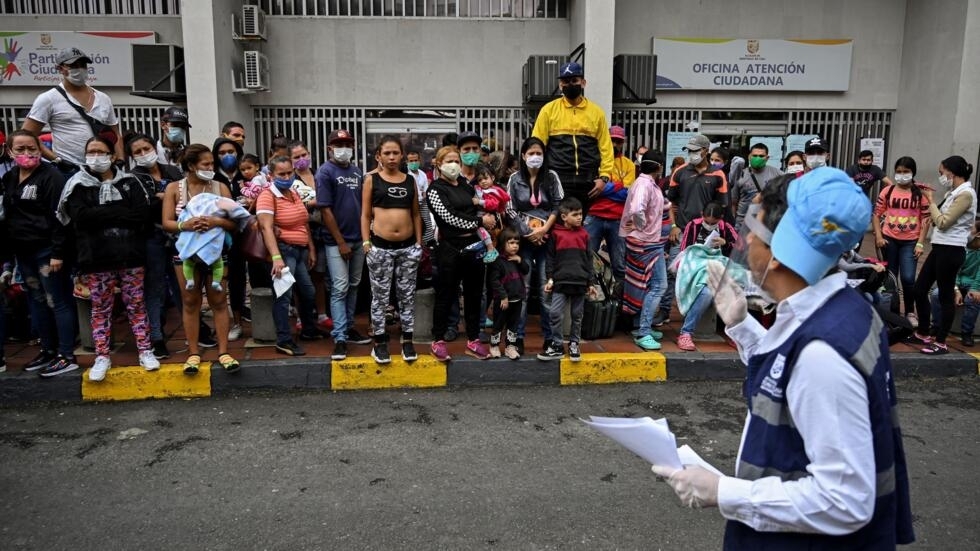 Migrantes venezolanos esperan un autobús para volver a su país, el 14 de abril de 2020 en Cali (Colombia)