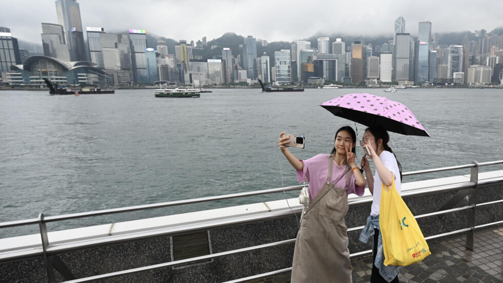 Unas turistas se fotografían en el paseo marítimo de Tsim Sha Tsui, en Hong Kong, el 1 de mayo de 2024