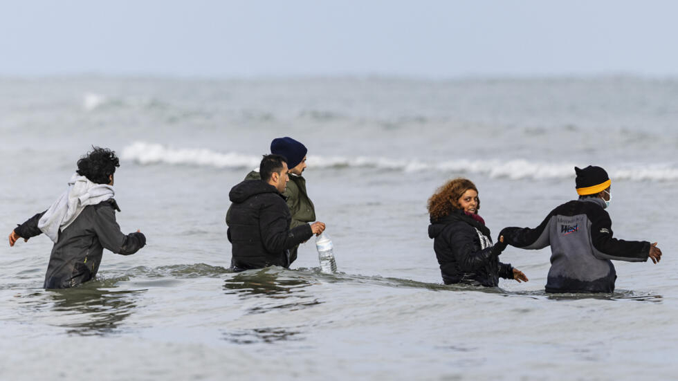 Unos migrantes entran en el agua para abordar una embarcación e intentar cruzar el canal de la Mancha, el 26 de abril de 2024 en una playa en Gravelines, en el norte de Francia
