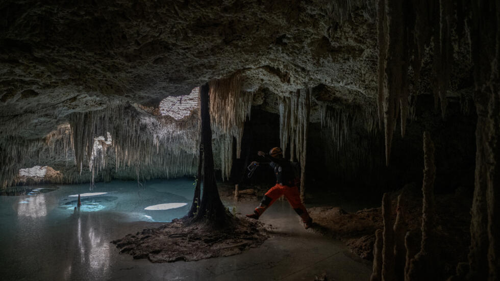 El ambientalista Guillermo DChristy atraviesa un área de agua dentro de un cenote cerca de Playa del Carmen, en México, el 22 de abril de 2024