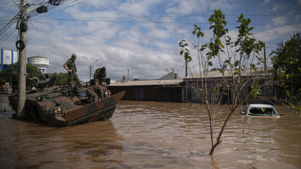 Unos soldados observan un vehículo abandonado en una calle inundada en Eldorado do Sul, en el estado brasileño de Rio Grande do Sul, el 9 de mayo de 2024