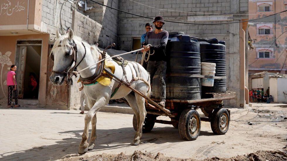 Un palestino transporta contenedores de agua en un carro tirado por un caballo el 15 de mayo de 2024 en Deir el Balah, en el centro de la Franja de Gaza