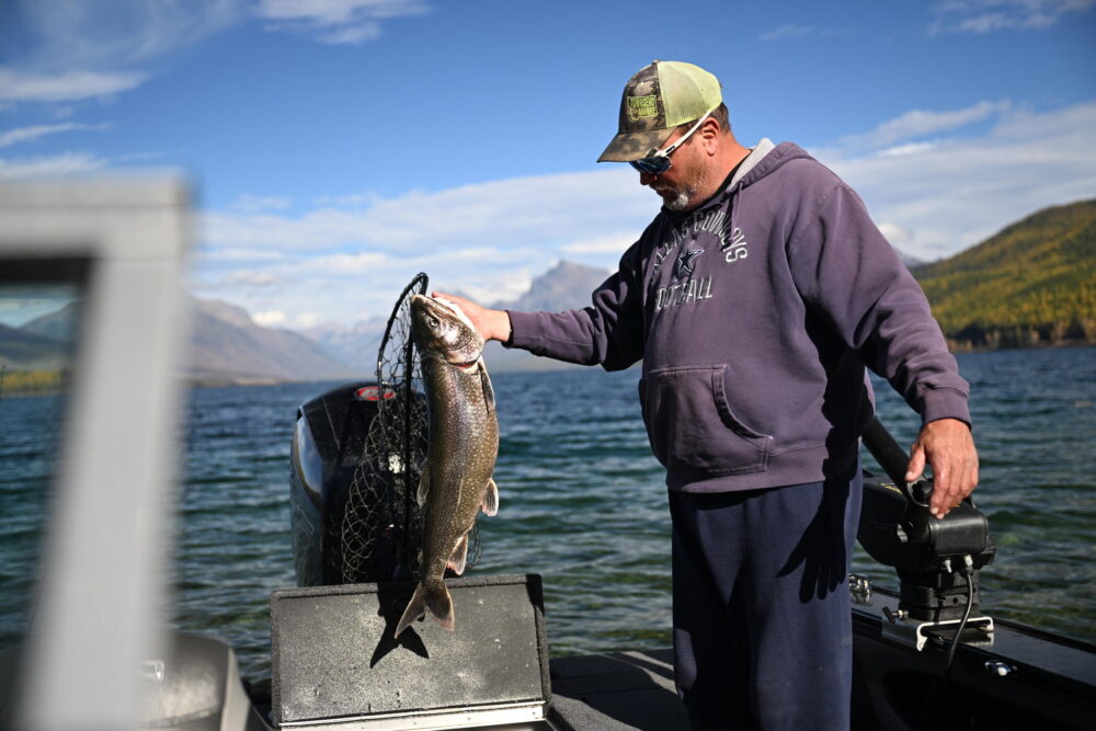 Un pescador muestra una trucha introducida para la pesca en el lago McDonald del Parque Nacional Glacier, en Montana, Estados Unidos, el 18 de octubre de 2023