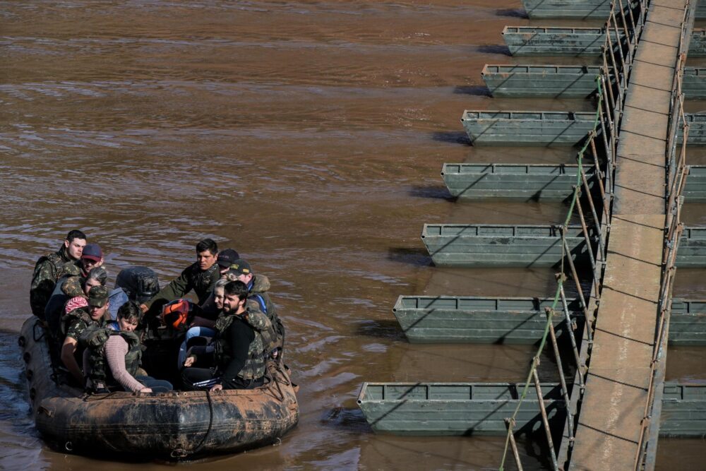 Militares ayudan a la gente a cruzar en barco de Arroio do Meio a Lajeado, sobre el río Forquilha, ya que el puente sobre el río en la Rodovia RS130 se cayó durante las recientes inundaciones, en el estado de Rio Grande do Sul, Brasil, el 15 de mayo de 2024