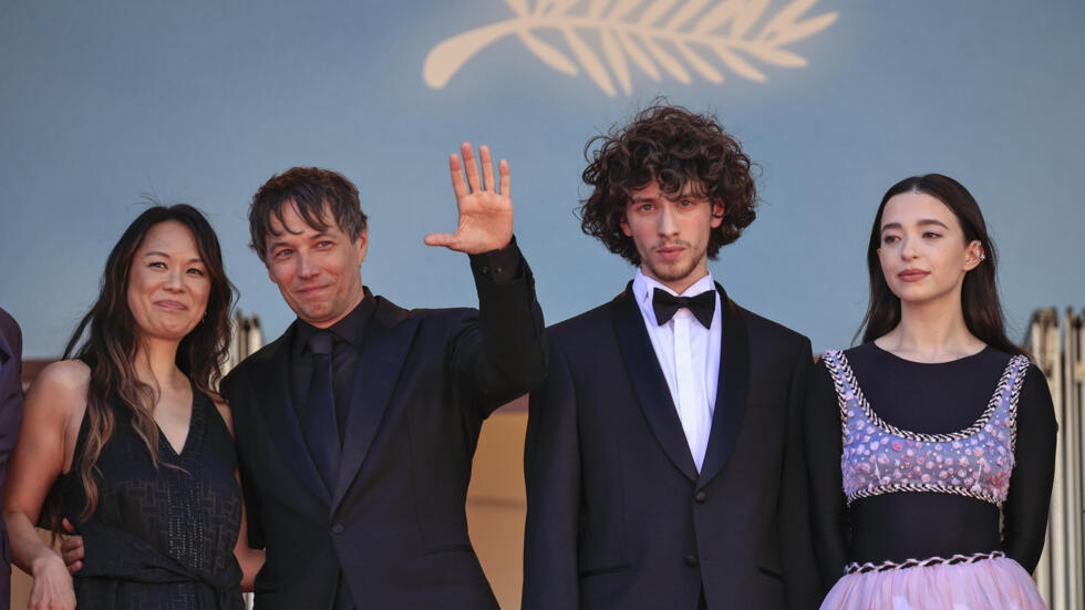 El cineasta estadounidense Sean Baker saluda junto al equipo de su película "Anora", en el Festival de Cannes, en Francia, el 21 de mayo de 2024