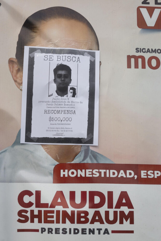Feminista radical del Bloque Negro pega cartel de búsqueda con la foto de un presunto femenicida en un cartel electoral de la favorita para las elecciones presidenciales del 2 de junio Claudia Sheinbaum en México el 16 de mayo de 2024.