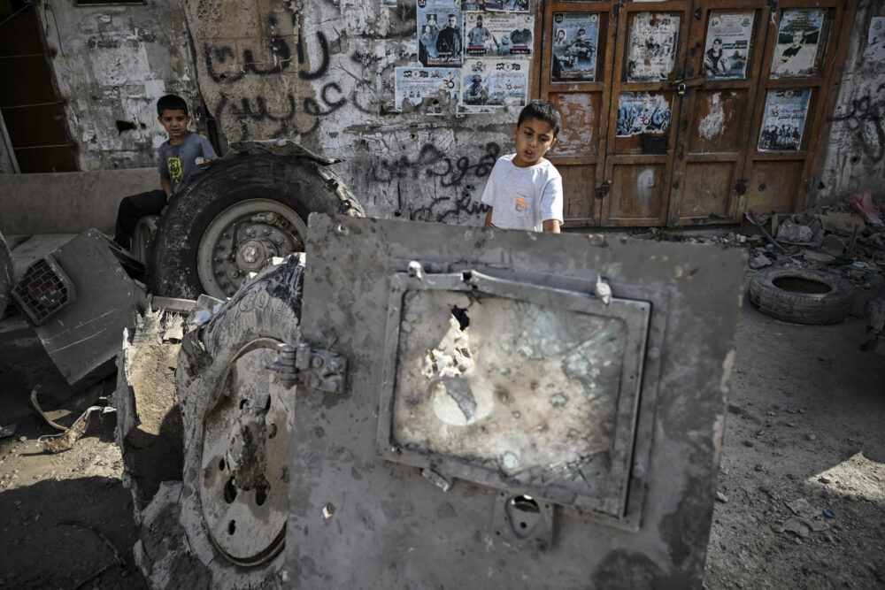 Niños palestinos detrás de un vehículo destruido en Yenín tras un operación militar israelí