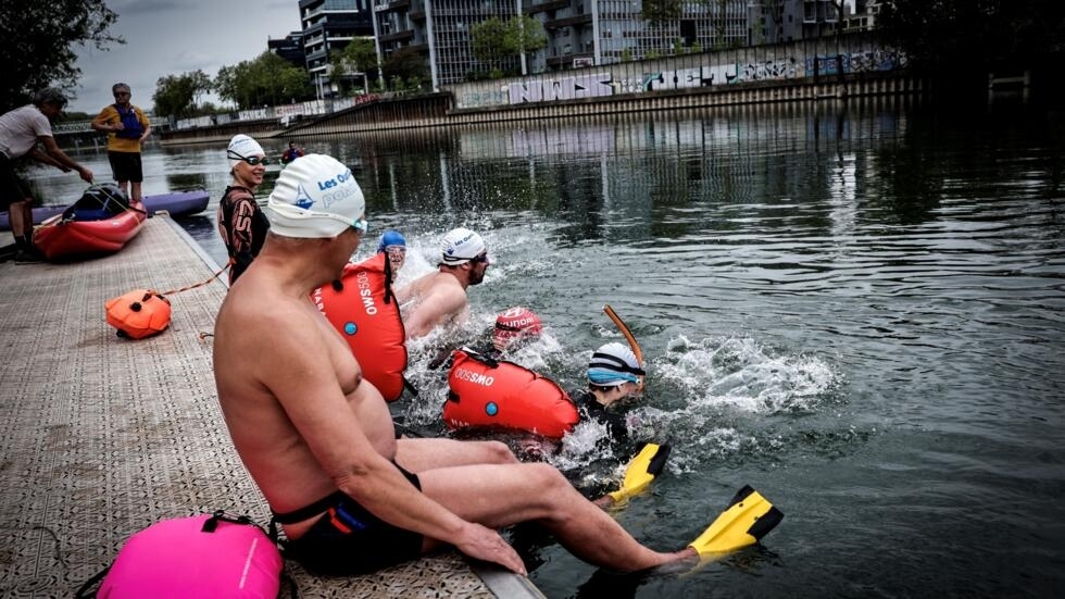Un grupo de bañistas se sumerge en el río Sena para nadar, en Ile Saint Denis, al norte de París, el 1 de mayo de 2024