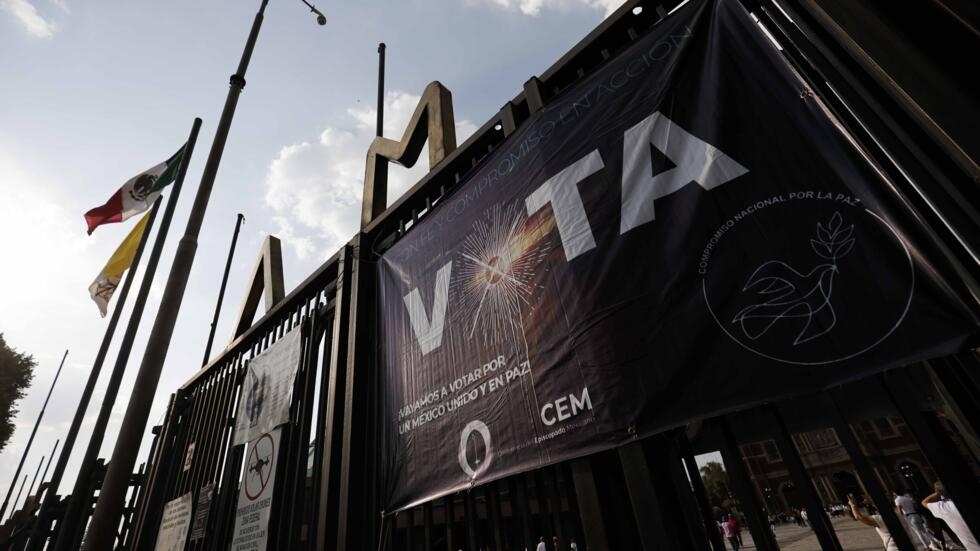 Vista de un cartel que anima a concurrir a votar en las elecciones generales y presidenciales del 2 de junio de 2024 en México, colgado al frente de la Basílica de Guadalupe de la capital mexicana