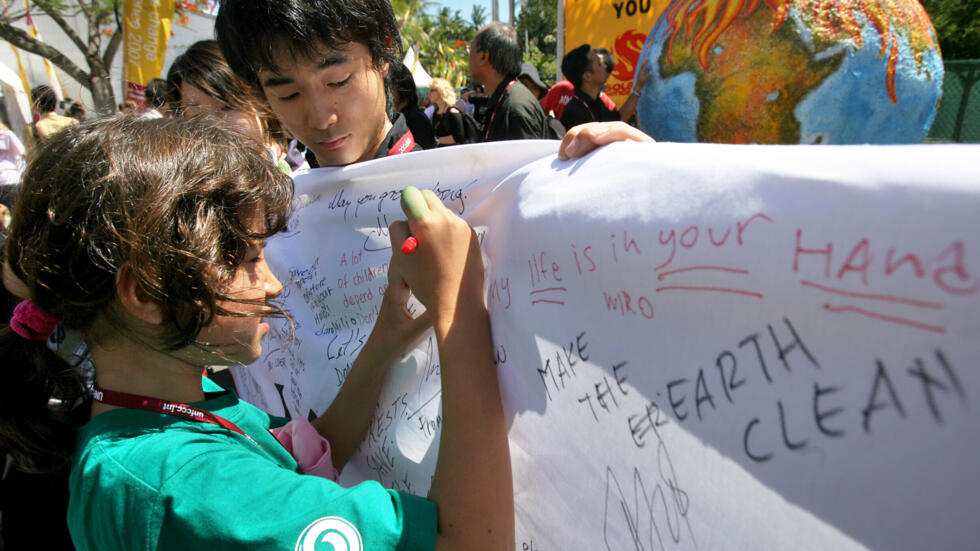 Una niña firma una pancarta en una manifestación en Nusa Dua, en la isla indonesia de Bali, el 14 de diciembre de 2007, durante una Conferencia de la ONU contra el Cambio Climático