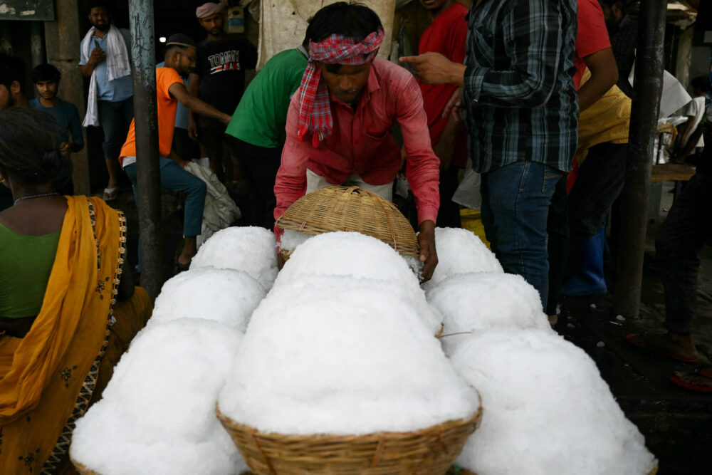 Un trabajador transfiere cestas de hielo raspado a un procesador de alimentos en un mercado de Nueva Delhi el 29 de mayo de 2024, en plena ola de calor