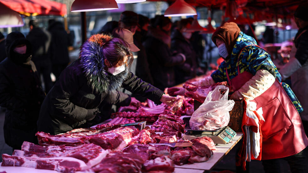 Unos clientes compran carne el 12 de enero de 2024 en un mercado en Shenyang, en el noreste de China