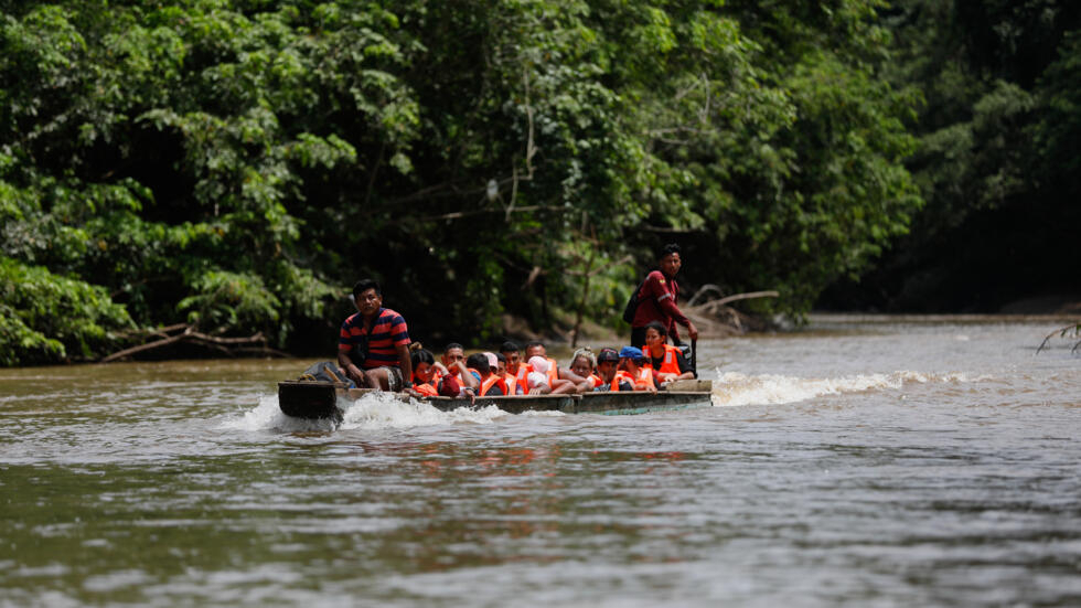 Migrantes navegan por un río en la selva del Darién en 6 de octubre de 2023