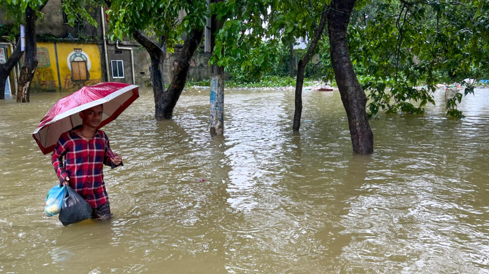 Un hombre vadea una zona inundada en Sylhet (Bangladesh) el 19 de junio de 2024