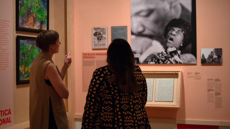 Las comisarias de la exposición "Changing the Face of Democracy: Shirley Chisholm at 100 ("Cambiando el rostro de la democracia: Shirley Chisholm cumple 100 años)" en el Museo de la Ciudad de Nueva York, el 11 de junio de 2024, Sarah Seidman (izquierda) y Zinga Fraser (derecha) contemplan una foto de Chisholm.