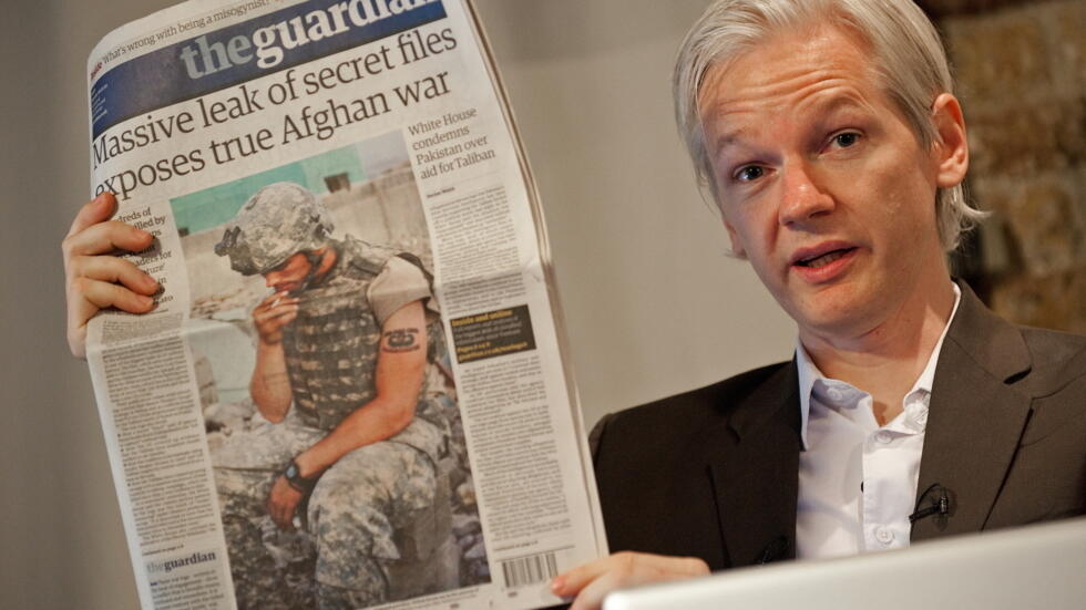 El australiano Julian Assange, fundador del sitio Wikileaks, muestra información secreta de EEUU divulgada por su plataforma y publicada en la portada del diario británico The Guardian, durante una rueda de prensa en Londres el 26 de julio de 2010