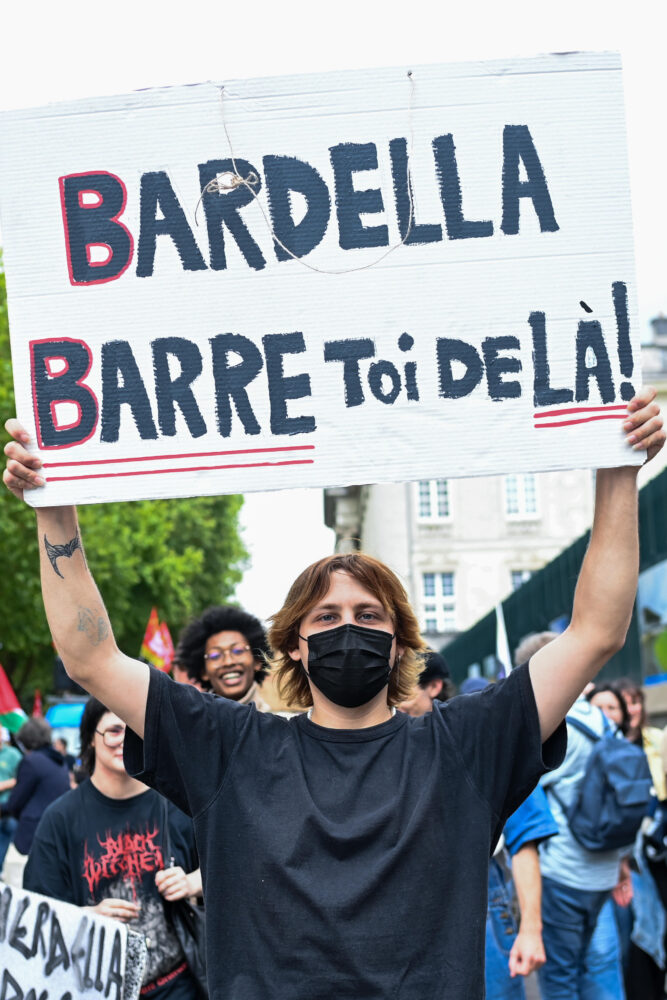 Un manifestante con una pancarta contra del candidato de Agrupación Francesa Jordan Bardella ("¡Bardella, lárgate de ahí!) durante una marcha contra la extrema derecha en Nantes, oeste de Francia, el 22 de junio de 2024