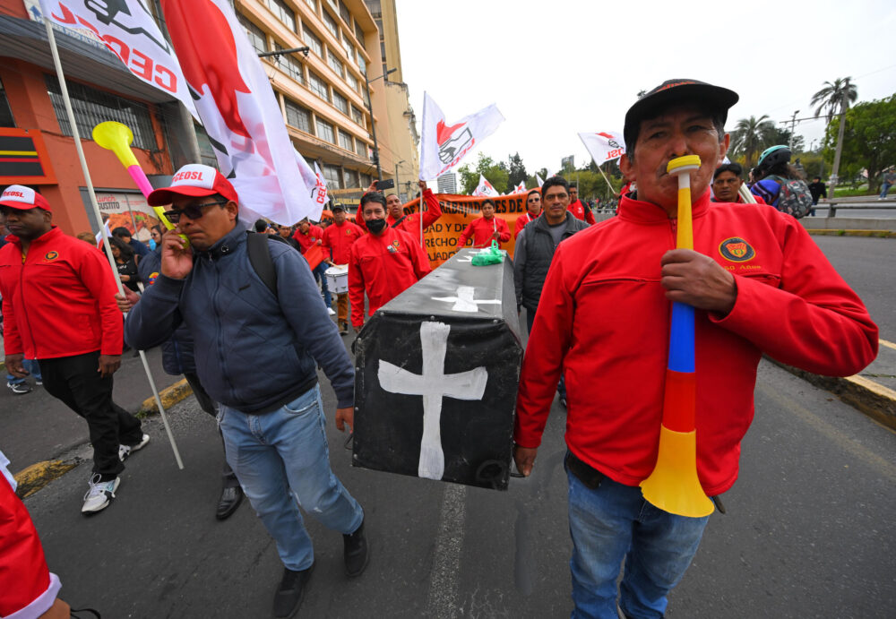 Personas portan una representación de un ataúd durante una concentración convocada por sindicatos y movimientos sociales para protestar por la subida del precio de los combustibles en Quito, el 4 de julio de 2024.