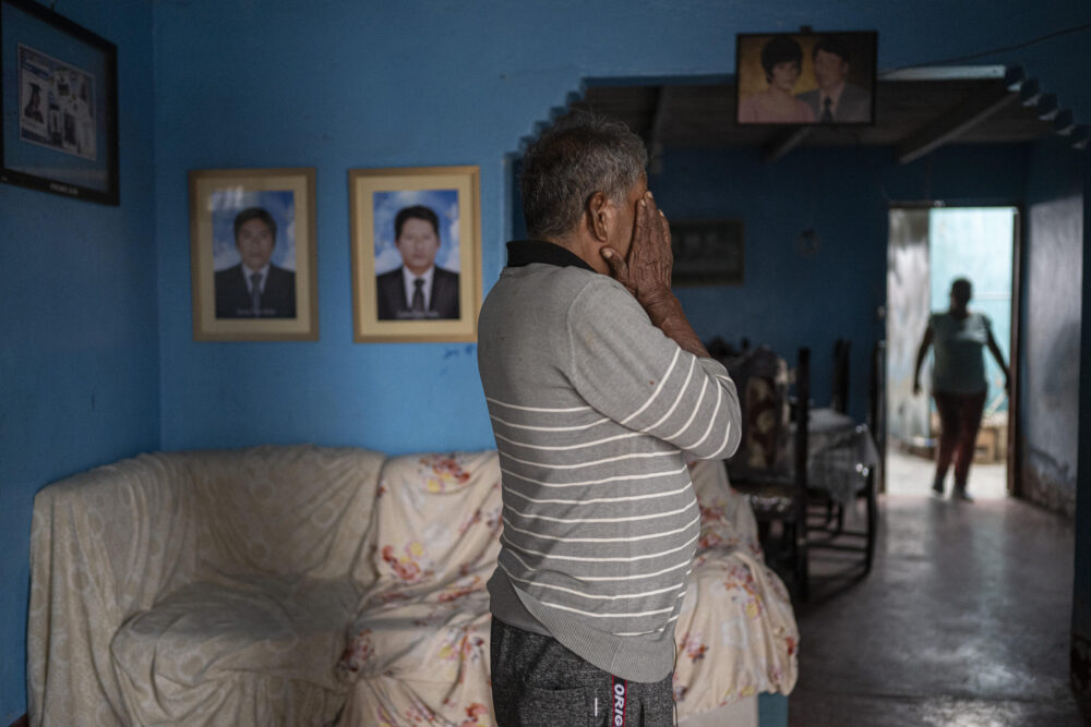 Carlos Flores, de 76 años, frente a las fotos de sus hijos que murieron de cáncer, presuntamente causado por los altos niveles de arsénico en sus cuerpoes en Huarmey, en el norte de Perú, el 25 de mayo de 2024