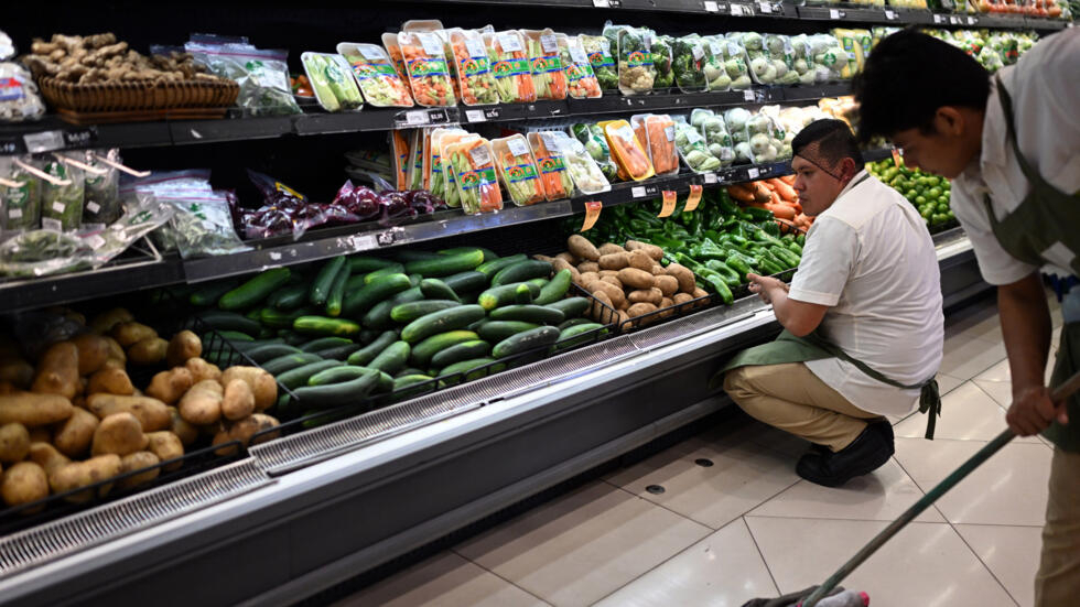 Un trabajador ordena frutas y verduras en un supermercado de San Salvador, el 8 de julio de 2024