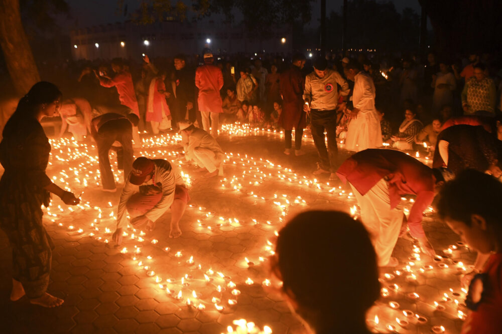 Fieles budistas encienden lámparas de aceite para conmemorar el aniversario de Buda en Lumbini, su pueblo natal en Nepal, el 16 de mayo de 2022