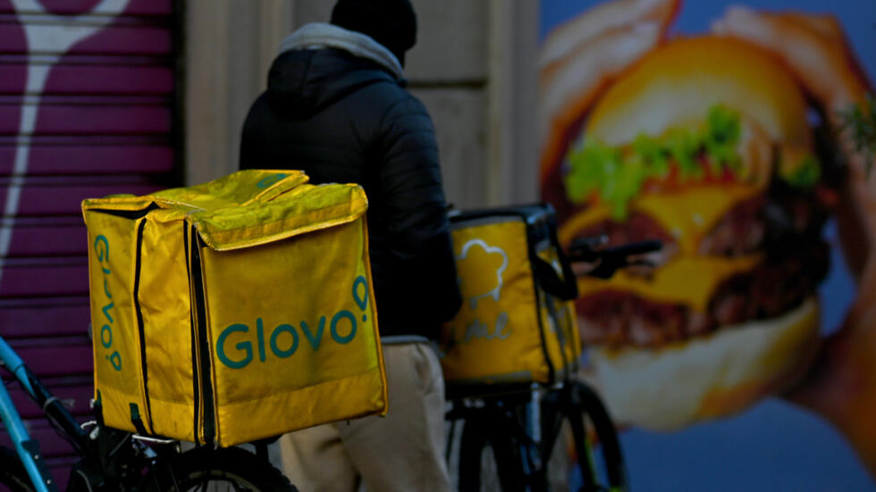 Un repartidor a domicilio de la empresa Glovo, con su bicicleta en una calle de Milán, en Italia, el 11 de enero de 2024