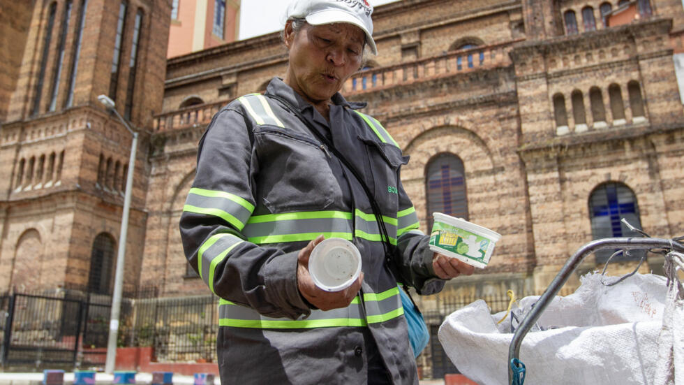 Miriam Calderón, de 68 años, recoge unos envases para reciclar en una calle del barrio de Las Cruces, el 17 de julio de 2024 en Bogotá