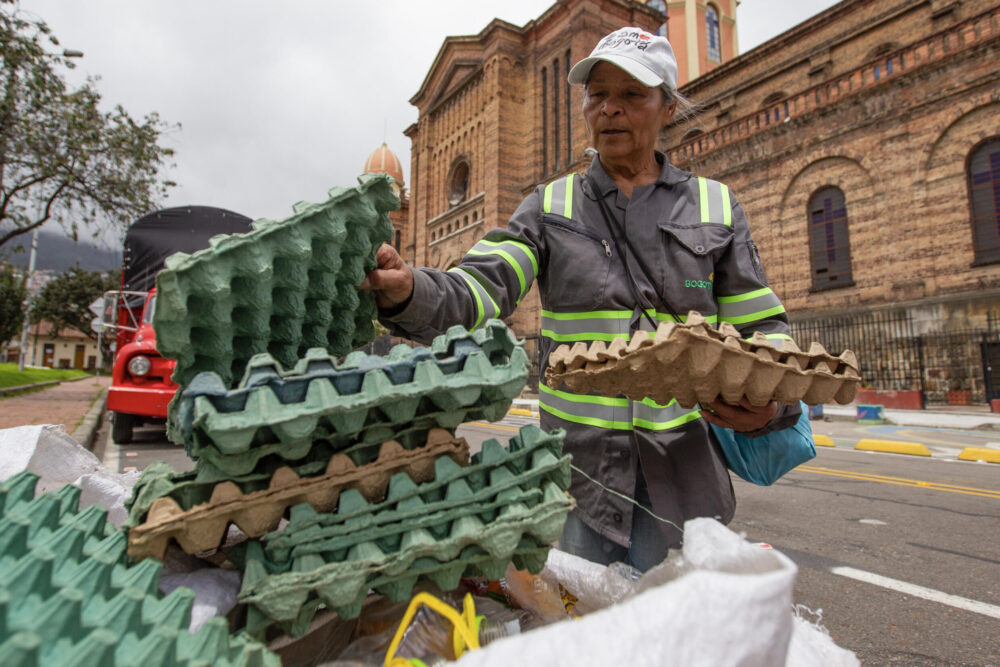 Miriam Calderón, de 68 años, apila cartones de huevos para reciclar en una calle del barrio de Las Cruces, el 17 de julio de 2024 en Bogotá