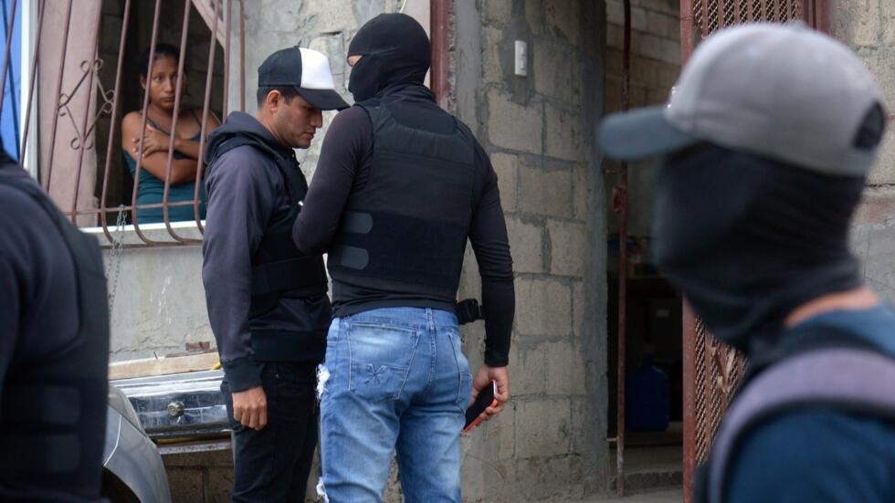 Una mujer mira por la ventana durante un operativo de militares y policías para recuperar viviendas tomadas por bandas del narcotráfico en Durán, a 10 km de Guayaquil, Ecuador, el 23 de julio de 2024