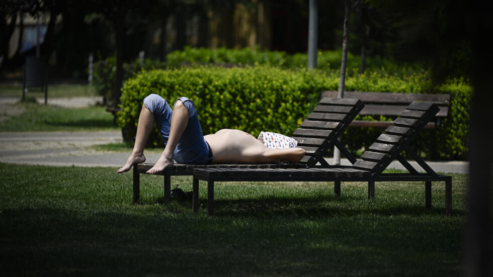 Una persona se solea en un banco de un parque público bajo 42ºC de calor en Sofía, capital de Bulgaria, el 18 de julio de 2024