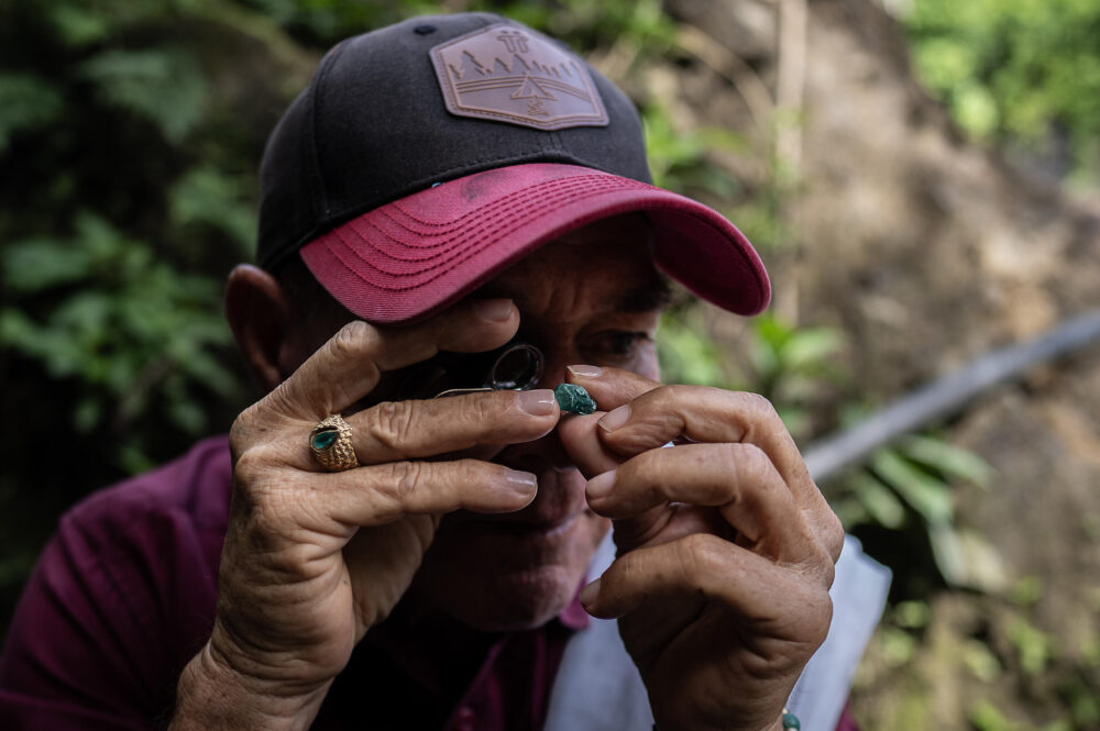 Un buscador de esmeraldas mira una gema en Muzo, Colombia, el 18 de junio de 2024