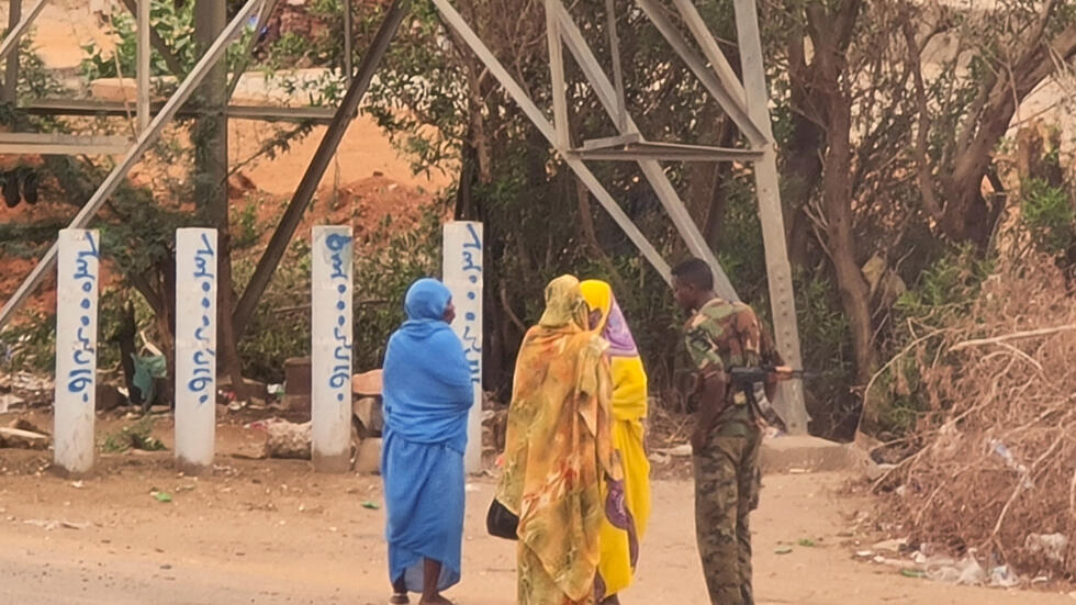 Un soldado habla con unas mujeres en una calle de la capital de Sudán, Jartum, el 6 de junio de 2023