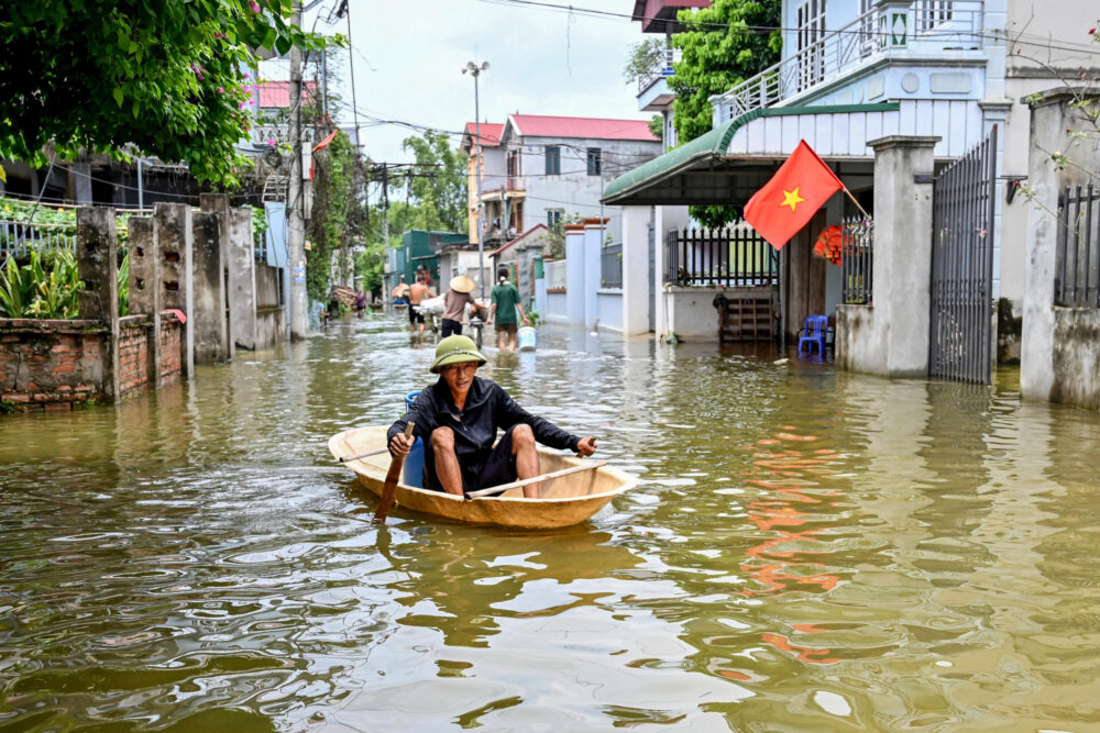 Un hombre se desplaza en barco en una calle inundada del pueblo de Ben Voi, cerca de Hanói, el 28 de julio de 2024