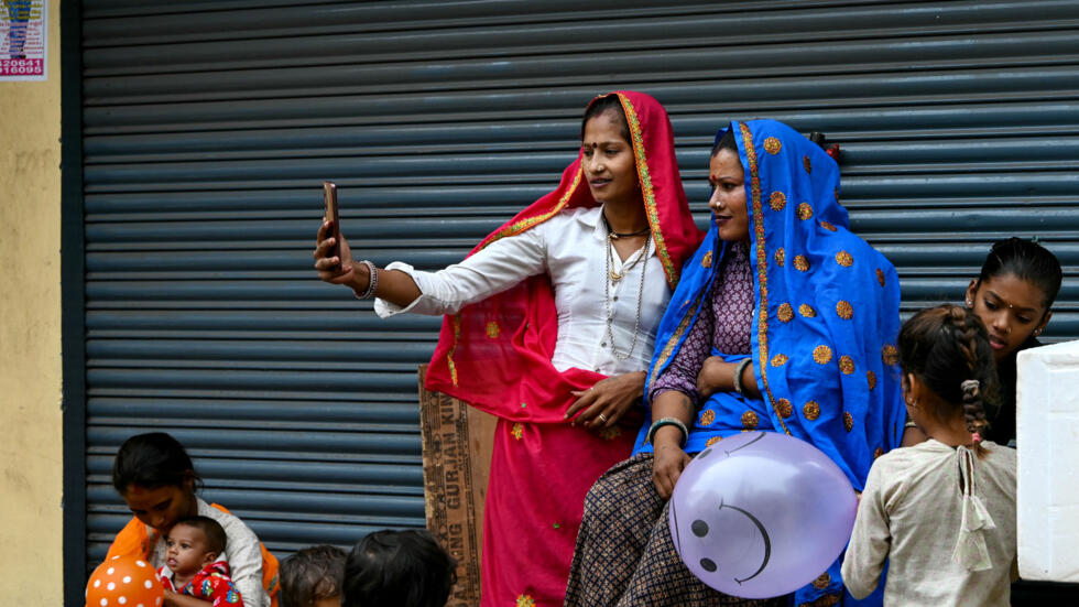 Mujeres se toman selfies con sus teléfonos móviles en una calle de Secunderabad, India, el 21 de julio de 2024.