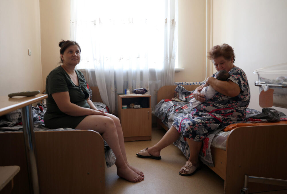 Tetiana, una habitante de Selidove, sostiene en brazos a su nieto Timofiy, nacido dos días antes, junto a su hija y madre del pequeño, también llamada Tetiana, en una habitación de la maternidad de Pokrovsk, en la región de Donetsk, el 20 de julio de 2024 al este de Ucrania