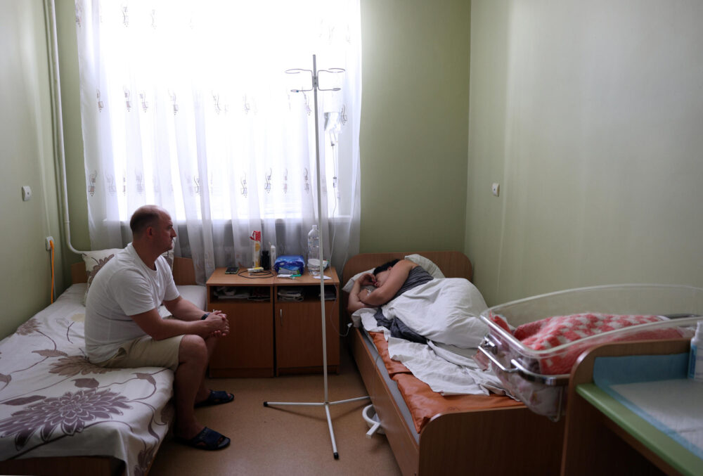 Serhii, de 37 años, observa a su esposa, Anastasia, de 32, que dio a luz el día anterior a la segunda hija de ambos, Olivia, en una habitación de la maternidad de Pokrovsk, en la región de Donetsk, el 20 de julio de 2024 al este de Ucrania