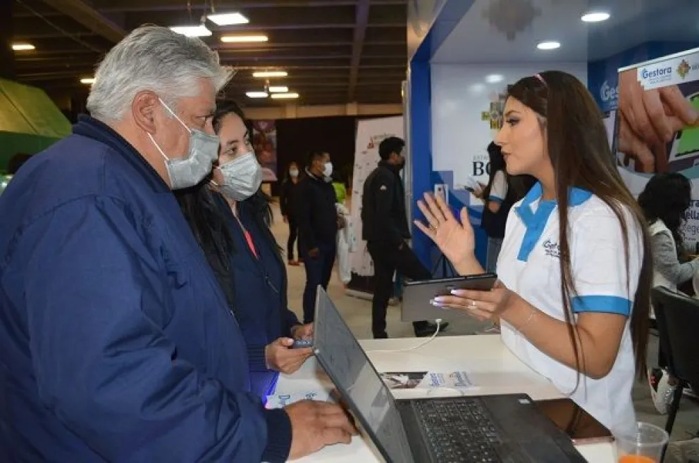 Una funcionaria brinda información a dos personas. Foto: ABI